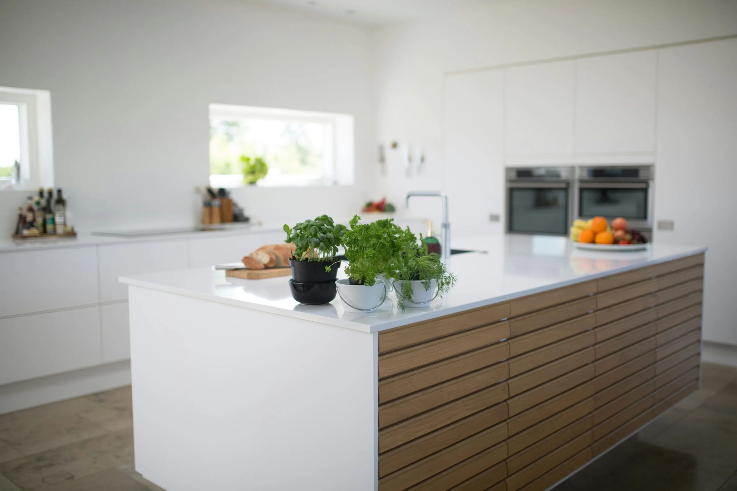Cuisine familiale rénovée avec grand îlot central blanc et bois
