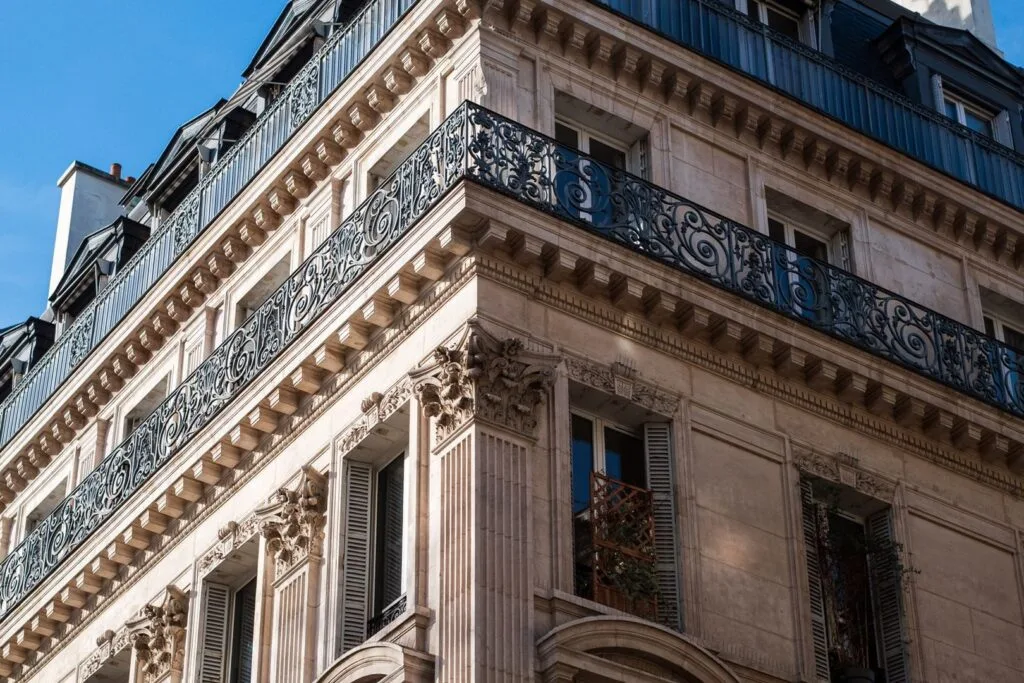 Détail de façade haussmannienne parisienne avec balcons en ferronnerie et corniches